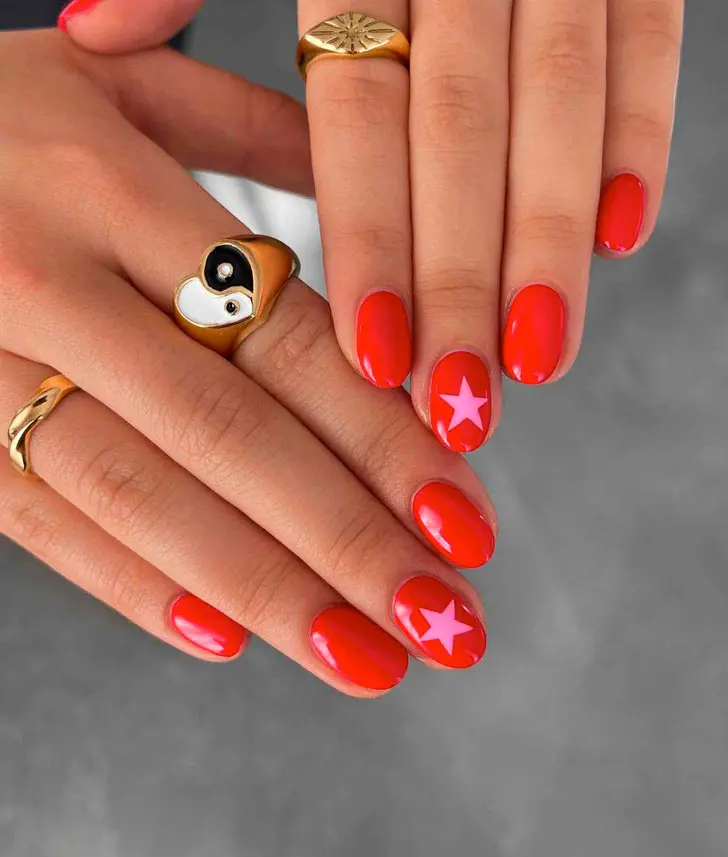 Красный маникюр с розовыми звездами на овальных коротких ногтях