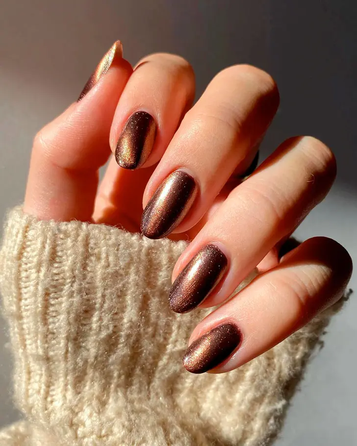 Праздничный коричневый маникюр с блестками на длинных овальных ногтях