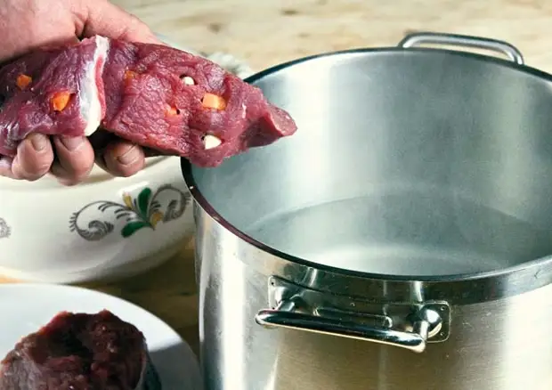 закладка нашпигованного мяса в кастрюлю с кипящей водой