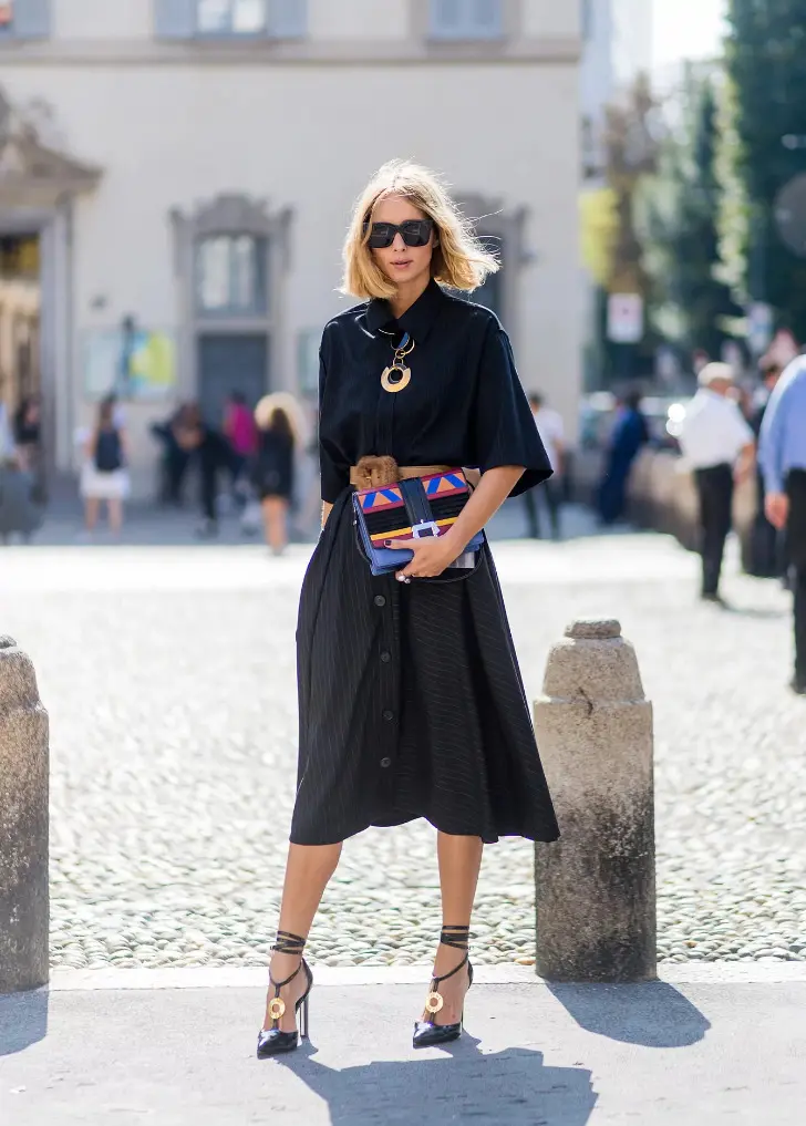 Девушка в черном платье миди, роскошных туфлях с ремешками на щиколотке и цветной сумкой
