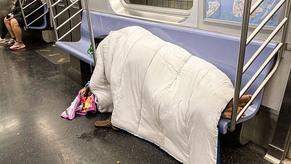 Бездомный в метро Нью-Йорка