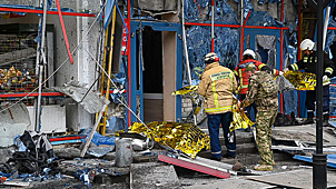 Спасательные службы у здания, поврежденного в результате обстрела города со стороны ВСУ