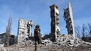 Военнослужащий у разрушенного многоэтажного дома в Авдеевке, февраль 2024 года