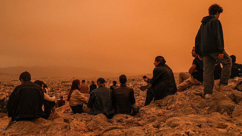 Туристы во время пылевой бури в Афинах